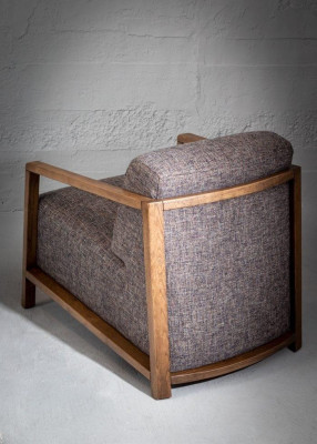 Stylishly compact mid-century armchair made of wood and upholstered fabric