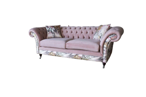 A vibrant three-seater Chesterfield sofa with a delicate pink floral pattern