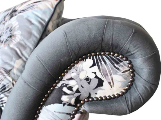 A striking three-seater sofa in a Chesterfield design with delicate gray floral decoration